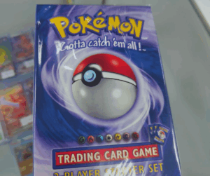 A close-up of a factory-sealed Pokémon TCG 2-Player Starter Deck from 1999, showing the Wizards of the Coast cellophane wrap.